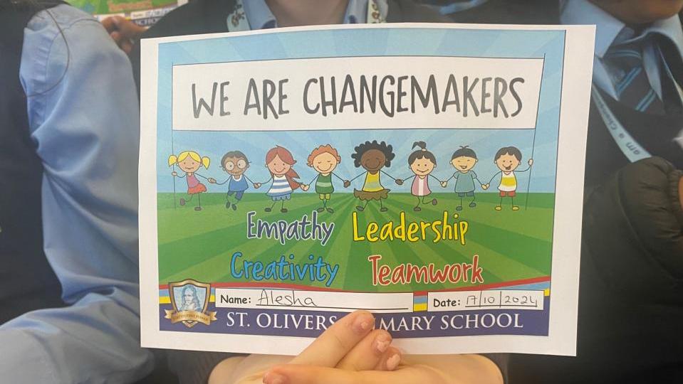 St. Oliver's Primary School Children holding a certificate to celebrate being a Changeaker school for 10 years.